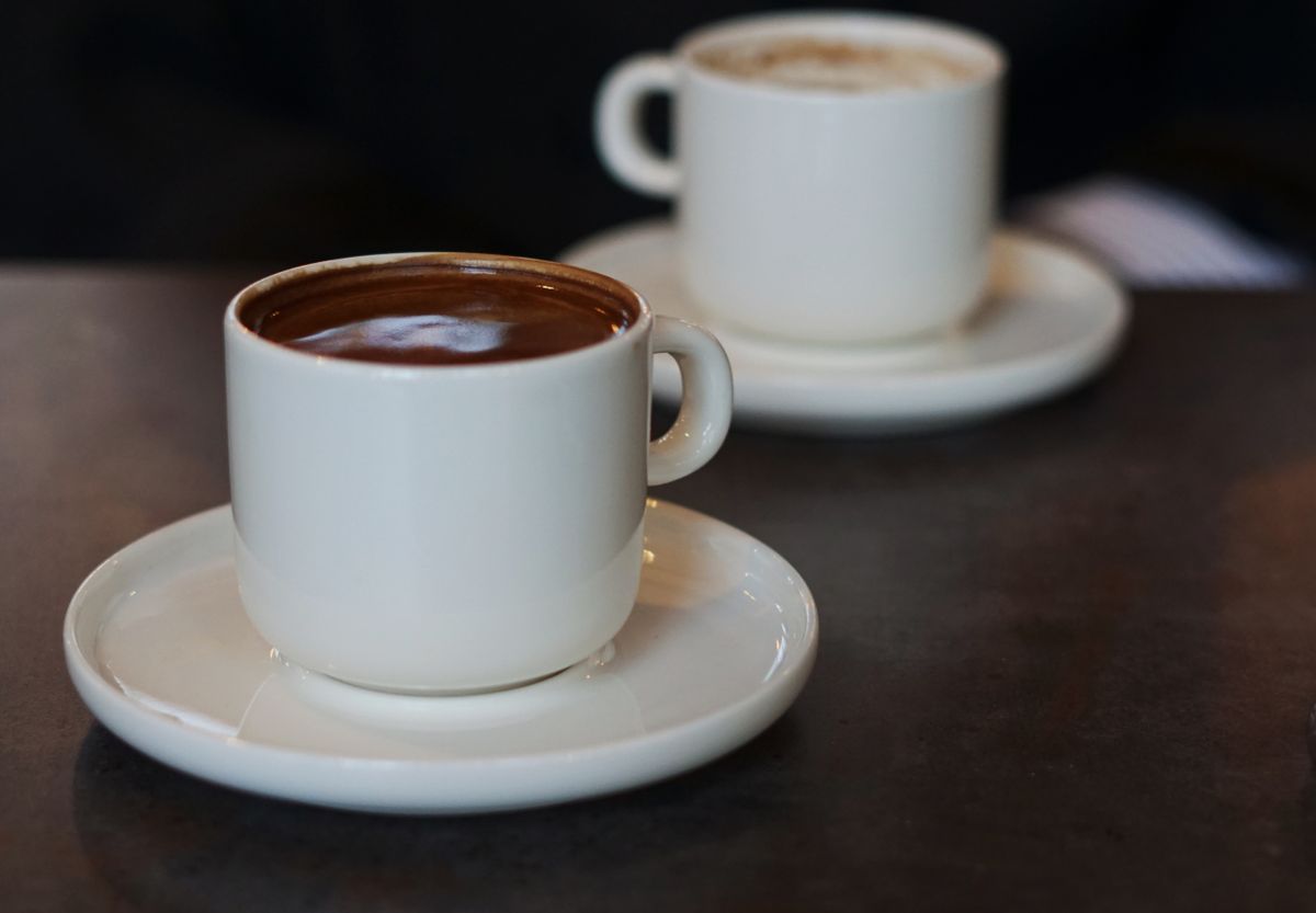 カフェのテーブルに置かれた2つのコーヒーカップ。向かい合って短い時間だけ話す場面のイメージ