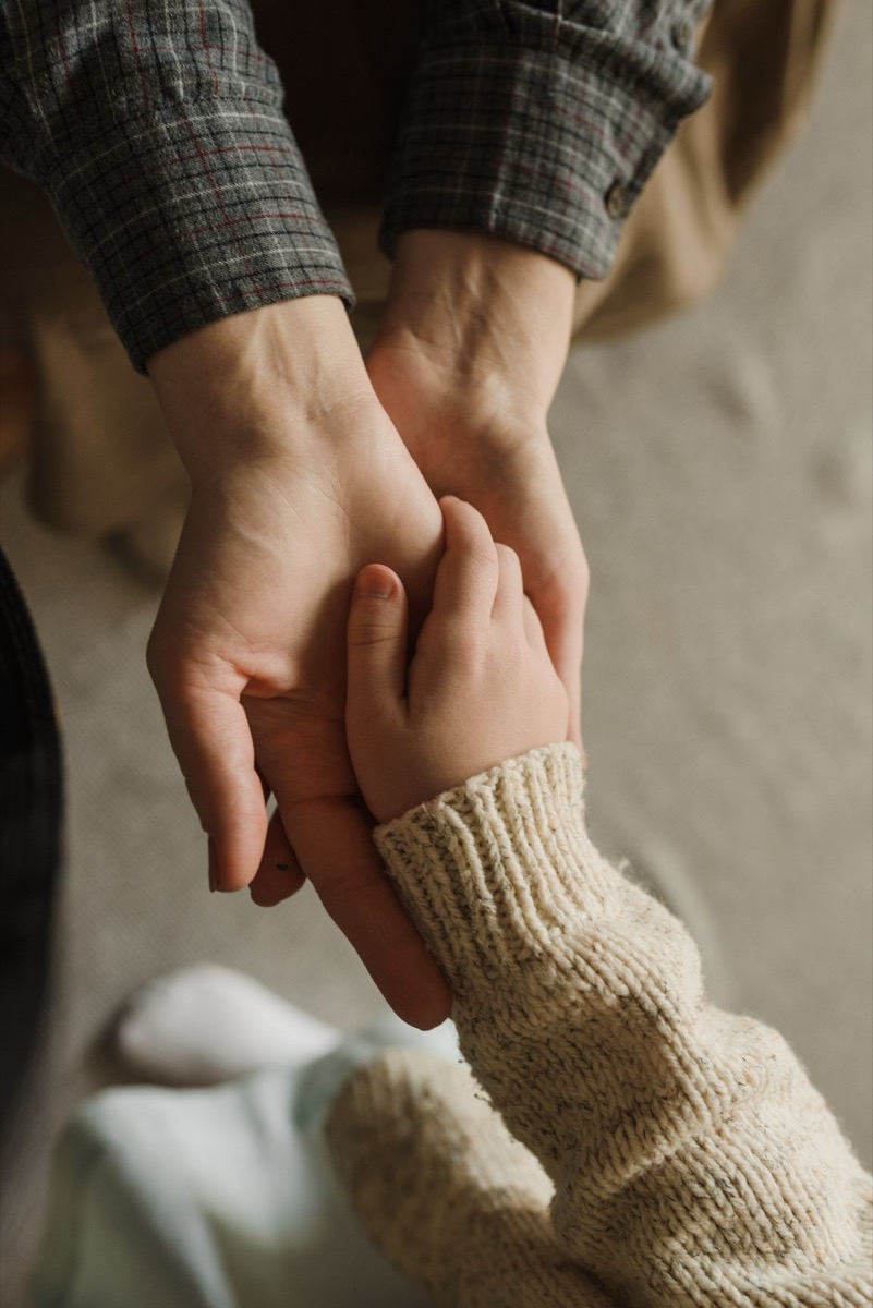 無理強いせず寄り添う関わりを表す、子どもの手をやさしく包む親の手
