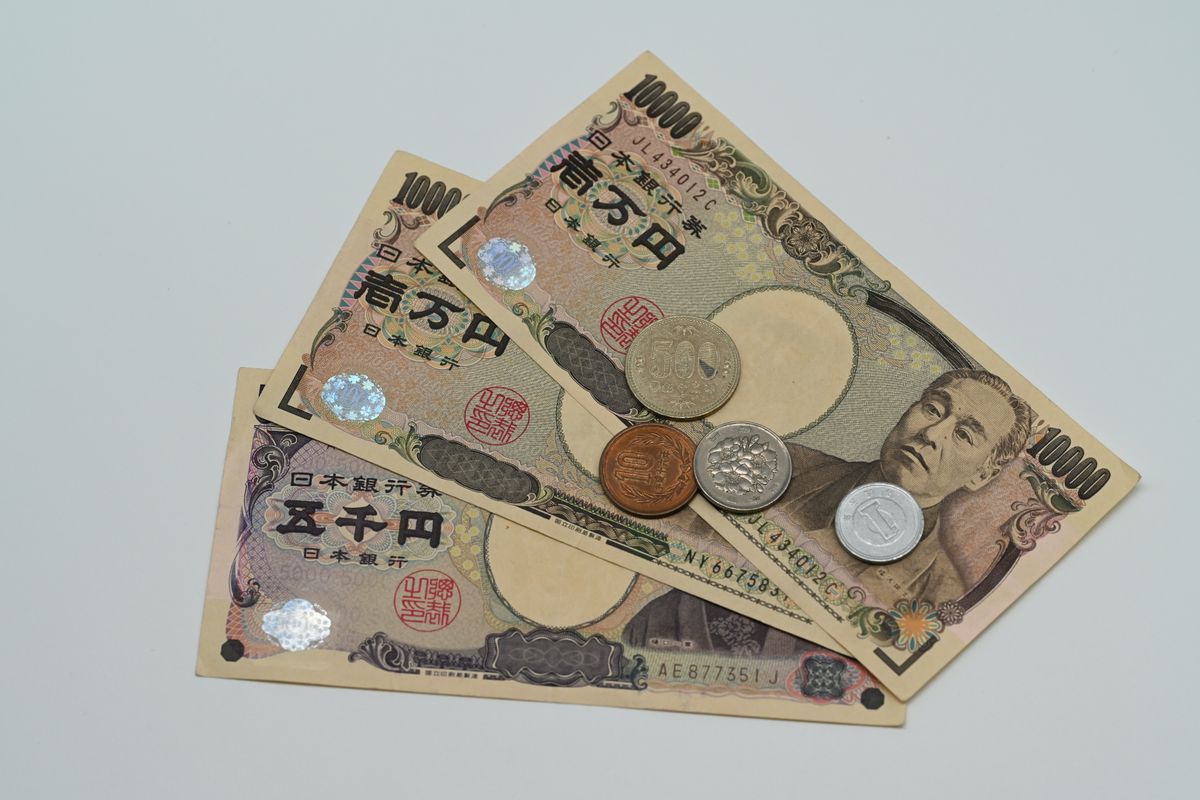 淡い背景に扇状に並べた日本の紙幣と硬貨。手当の金額や自己負担の上限を確かめる場面のイメージ